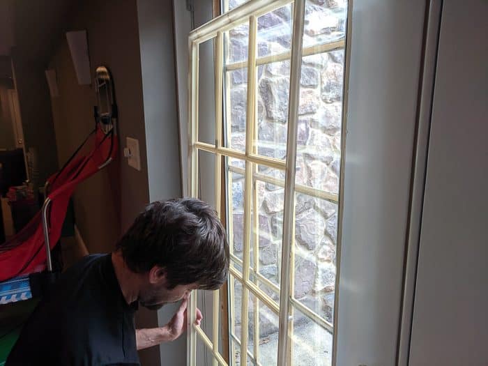 My husband removing the cheap plastic mullions on our glass door. These are junk and yellowed with age. I spray painted them. 