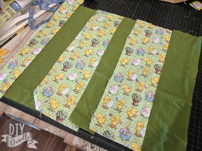 Piecing together Easter fabric with coordinating green fabric.