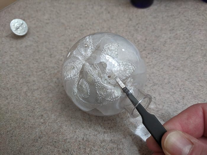 Using tweezers to fit the lace/fabric into the bulb.