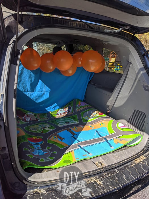 Setting up my trunk with backdrop, balloons, and a easy to clean mat. 