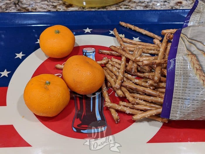 Making pumpkin oranges without celery- some easy peel oranges and pretzel sticks.