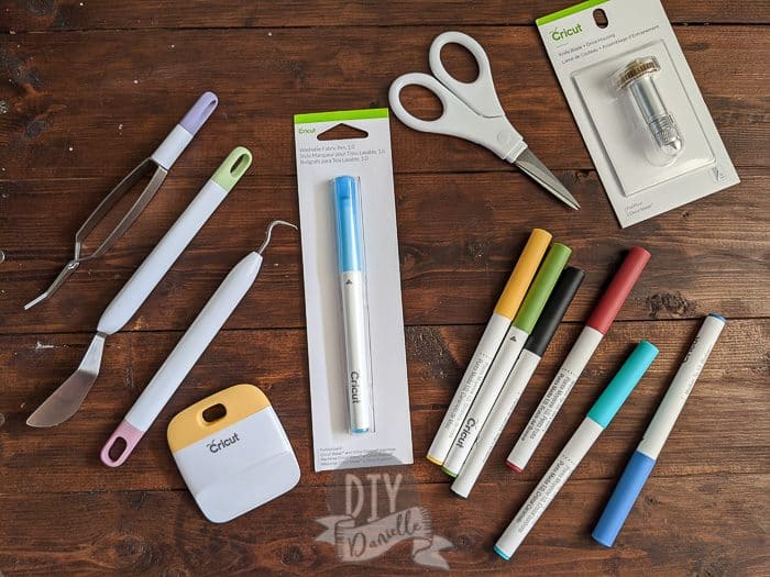 Cricut Supplies: Weeding tools and other accessories, scissors, pens, and a blade.