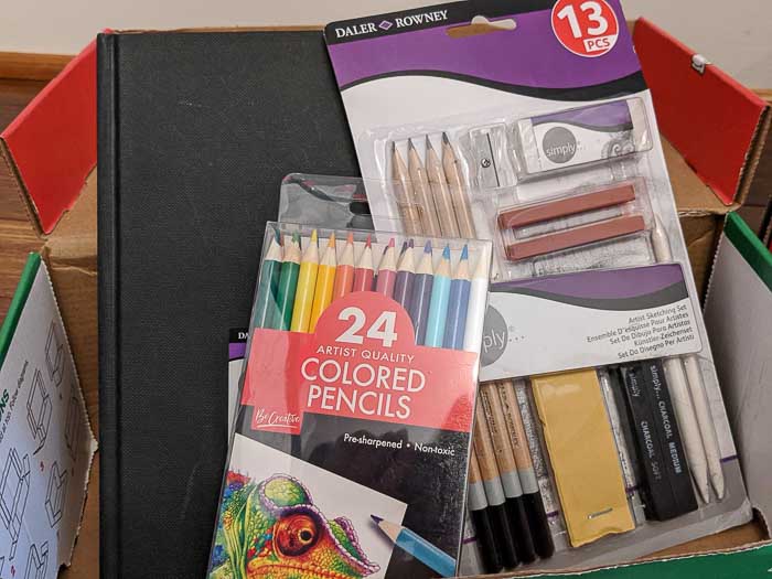 My son picked out some colored pencils, a drawing kit, and a sketchbook as art supplies to go in a box for a boy, 5-9 years old. 
