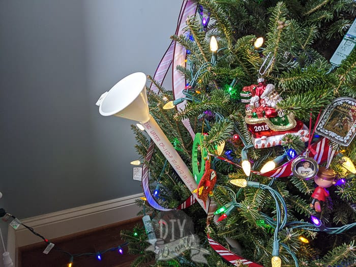 Setting up an easy watering system for Christmas tree with a funnel and PVC pipe.