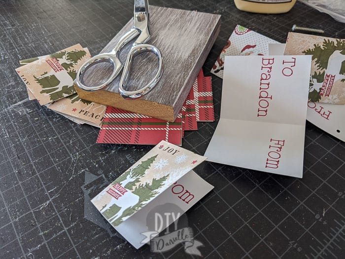 Folding gift tags then weighing them down so they stay folded.