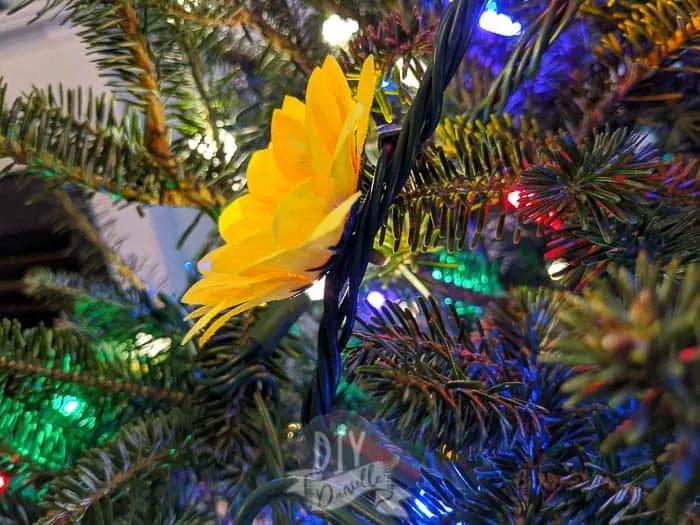 The fake sunflower stem can be inserted into the cords of your Christmas lights.
