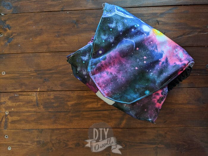 Easy diaper for a male goat (belly wrap) with hook and loop and galaxy print PUL.
