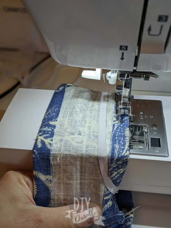 Sliding elastic over the fabric so you can fold the fabric over the elastic.