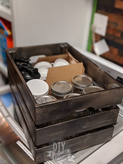 Storage bin with mason jars inside it and other canning supplies.