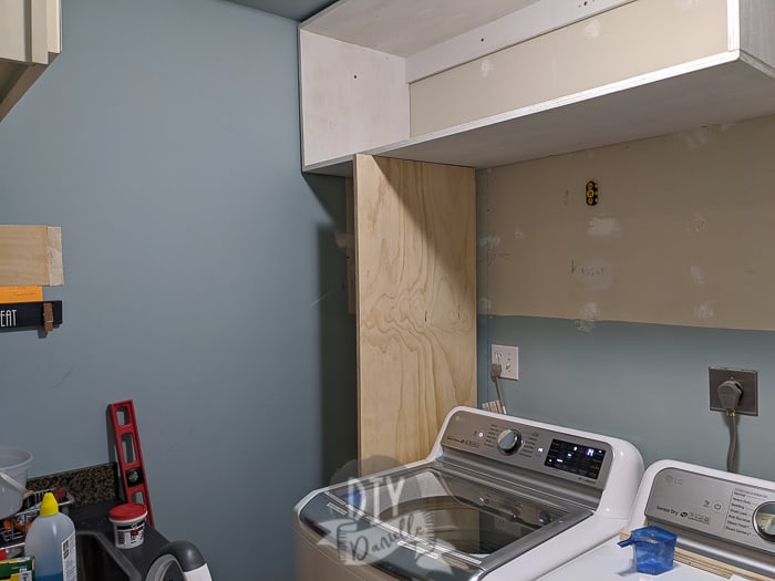 Piece of plywood being placed for the laundry shelf.