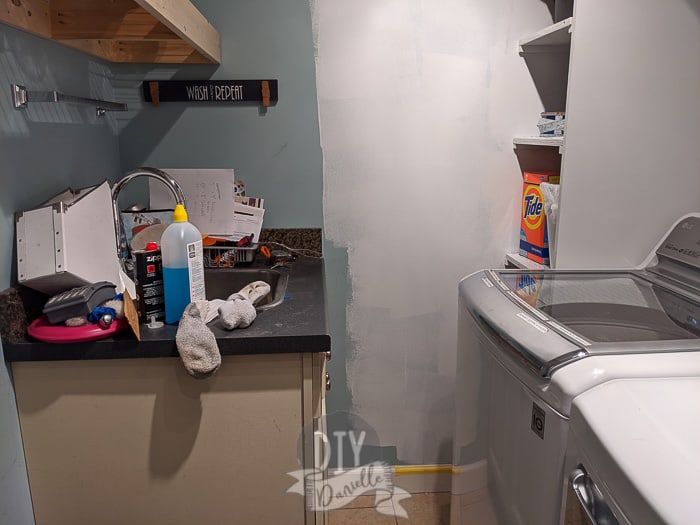 Overly large wash sink in a laundry room. Very little space between the washing machine and sink. 