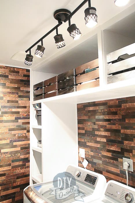 Close up of lighting, storage bins, and backsplash in this DIY mudroom and laundry room. 
