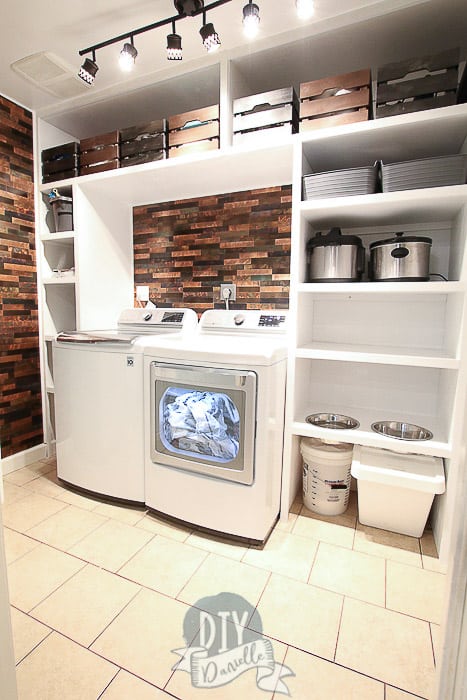 White DIY built in shelves for a laundry room with dog feeding station. Metallic backsplash.