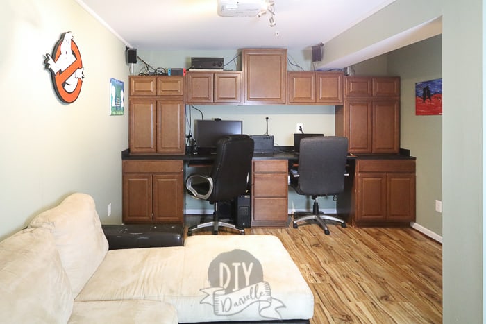 Cabinets used to create a built-in office area in a dark basement room.