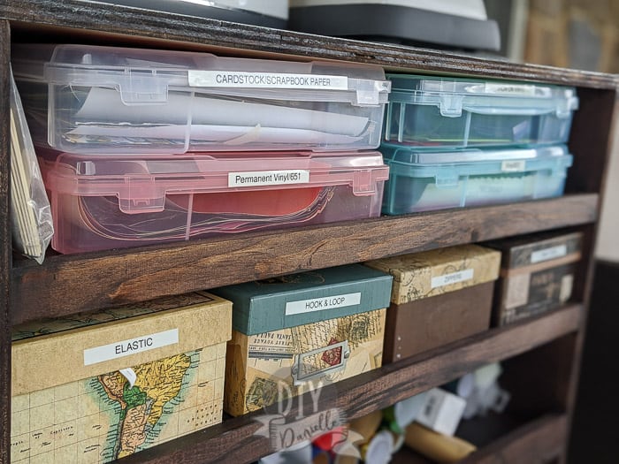 Vinyl stored in scrapbook paper bins with smaller photo boxes under for sewing supplies.