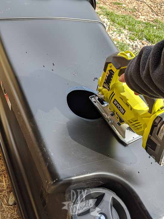 Cutting holes for goats to put nose through to get the hay. Using a jig saw.