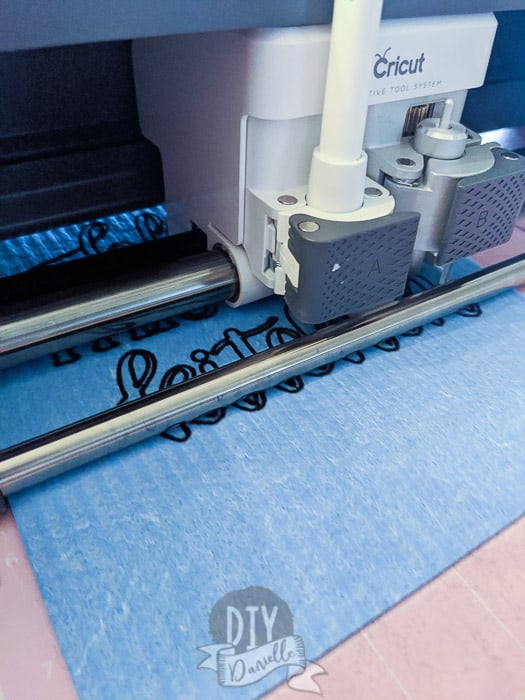 Cricut Maker writing on the dishcloth with a pen.