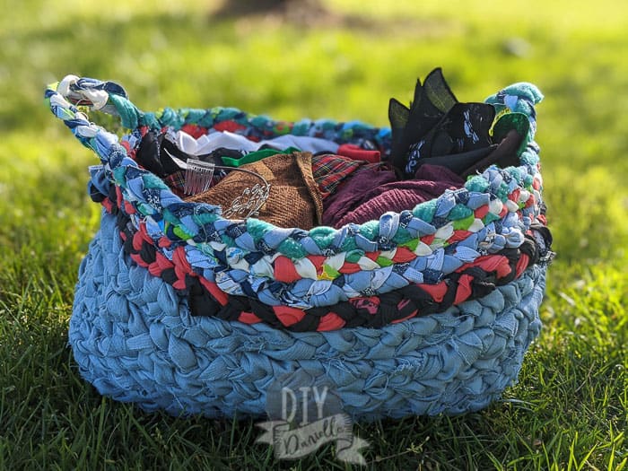 Storage basket made with upcycled fabric braided together. Two handles.