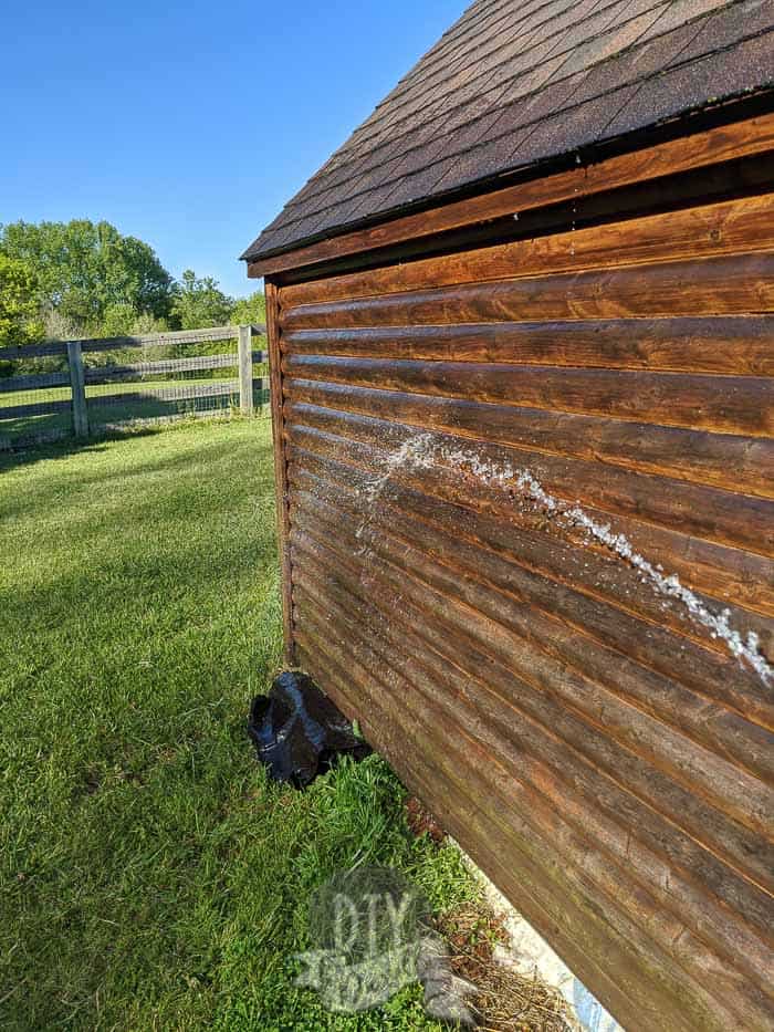 Rinsing soap and dirt off the sides of the playhouse.