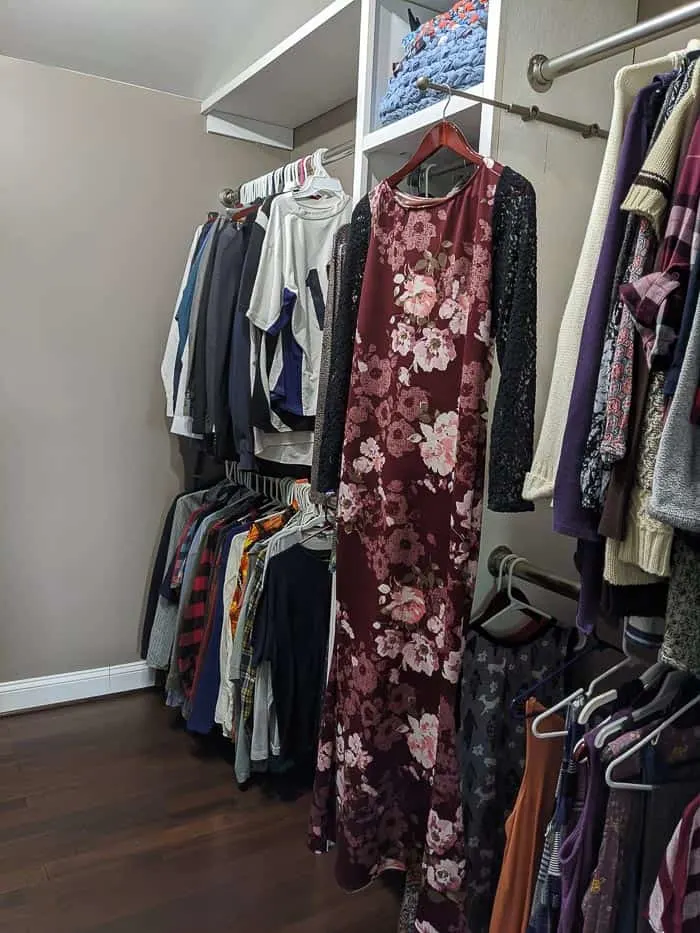 Silver/Chrome Valet rod that slides out from closet. It needs to be screwed into wood shelving or the wall. Floor length floral dress hanging from it.
