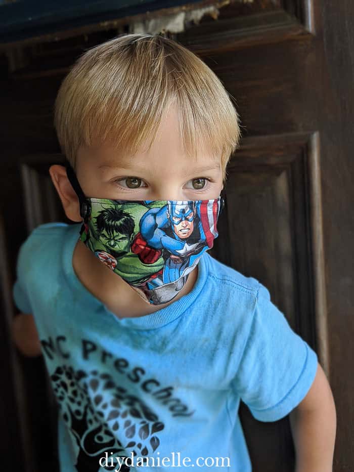 3 year old boy with blond hair wearing a super hero DIY kids mask with snaps on either side so they can breakaway in an emergency. 