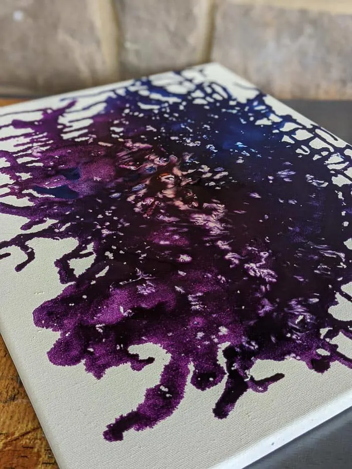 Crayon art on a white canvas with galaxy theme. Purple, blue, red, with white mixed in. 