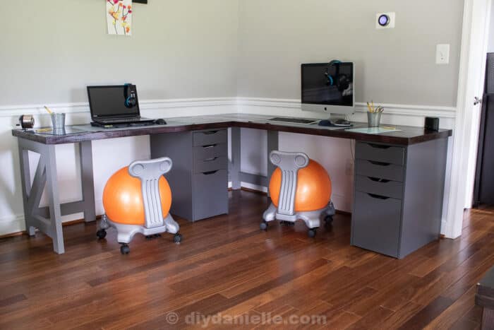 DIY 2 person corner desk for a kid's homeschooling area. Two computers, two yoga ball chairs, butcherblock countertops and gray Alex drawers from IKEA.