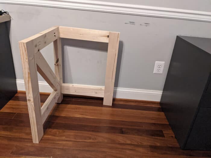 2x4s cut and assembled to function as a leg for the desk/butcherblock top. This is made with a diagonal support for a farmhouse style look to the desk.