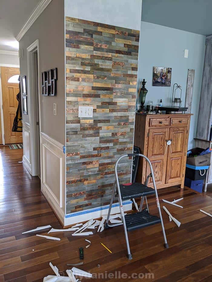 Picture of the peel and stick metal tiles on the feature wall, about 80% done with no trim on yet. Note the gap around the outside of the tile to place the trim.