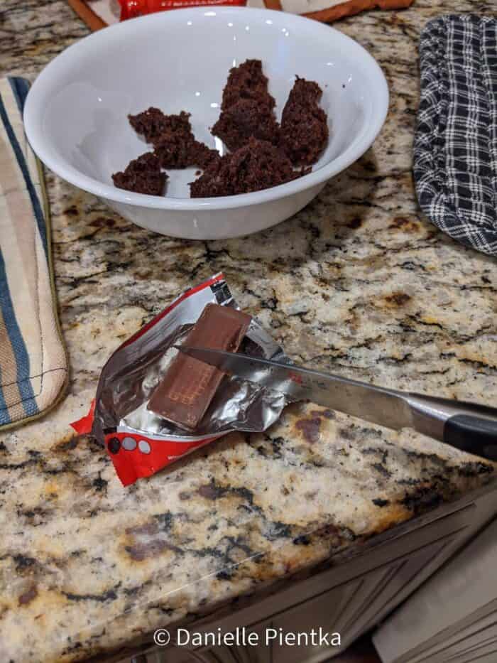 Cutting Kit Kats in half for a stem on the pumpkin.