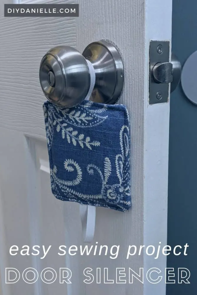 DIY Door Silencer, hanging loose off one door knob. Fabric is blue and beige old fashioned print.