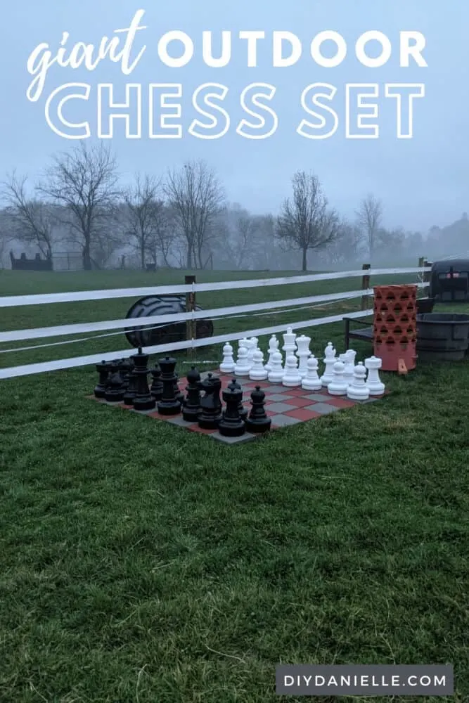 Large outdoor chess board in front of a field.