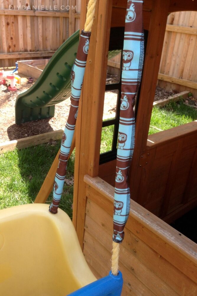 Owl fabric covers snapped over yellow scratchy rope on an old baby swing.