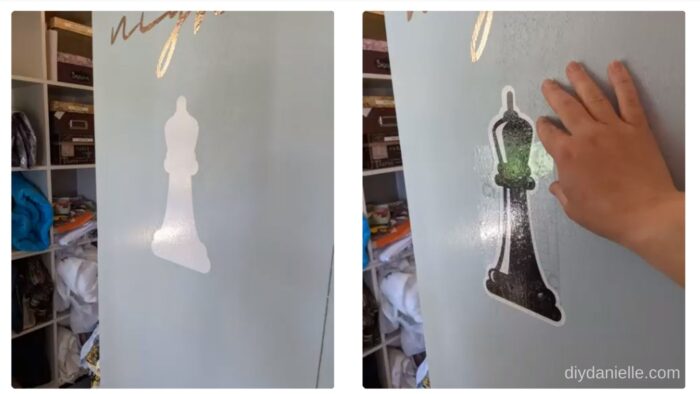 Using transfer tape to put a Chess queen cut from permanent vinyl on a cabinet.