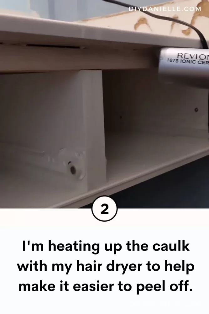 Heating up the caulk to help remove it.