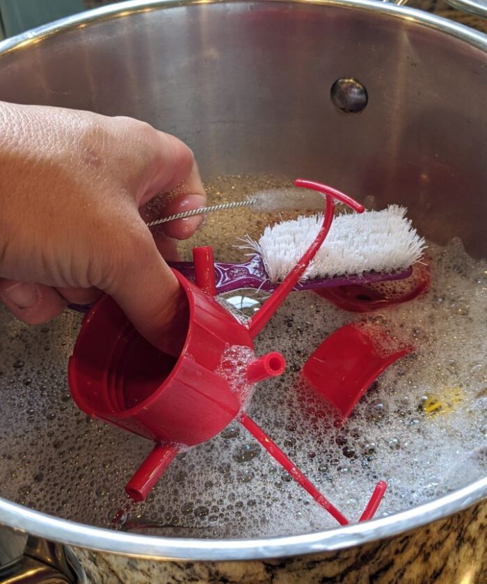 Soaking the pieces to the hummingbird feeder in soapy water.