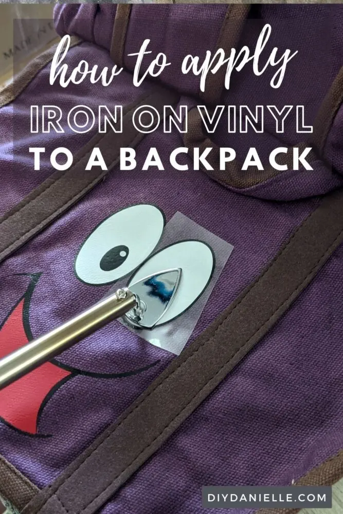 How to apply iron on to a backpack to customize it. Close up photo of a purple backpack with a face of HTV/iron on vinyl being added with the Clover minipress.