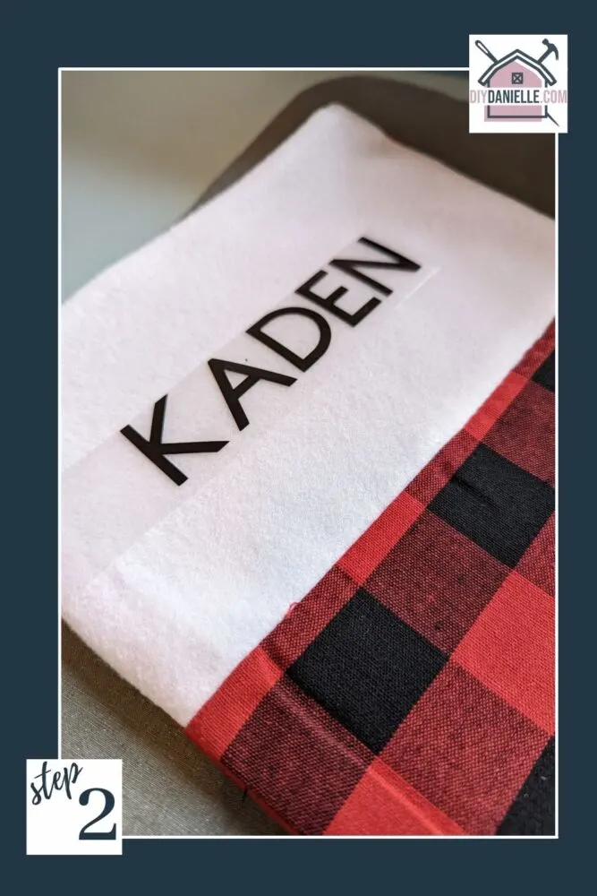 Name "Kaden" in HTV and weeded, laid on the white band of a Christmas stocking.