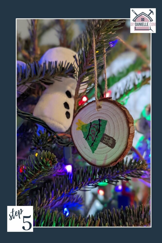 Handmade ornament from 2021 hanging on a Christmas tree