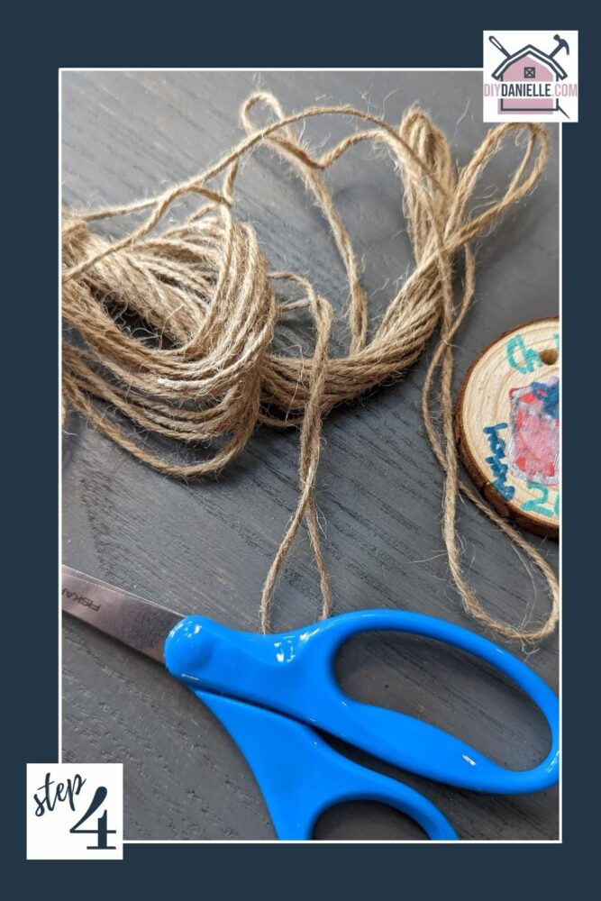 Wood slice ornament, twine, and scissors.