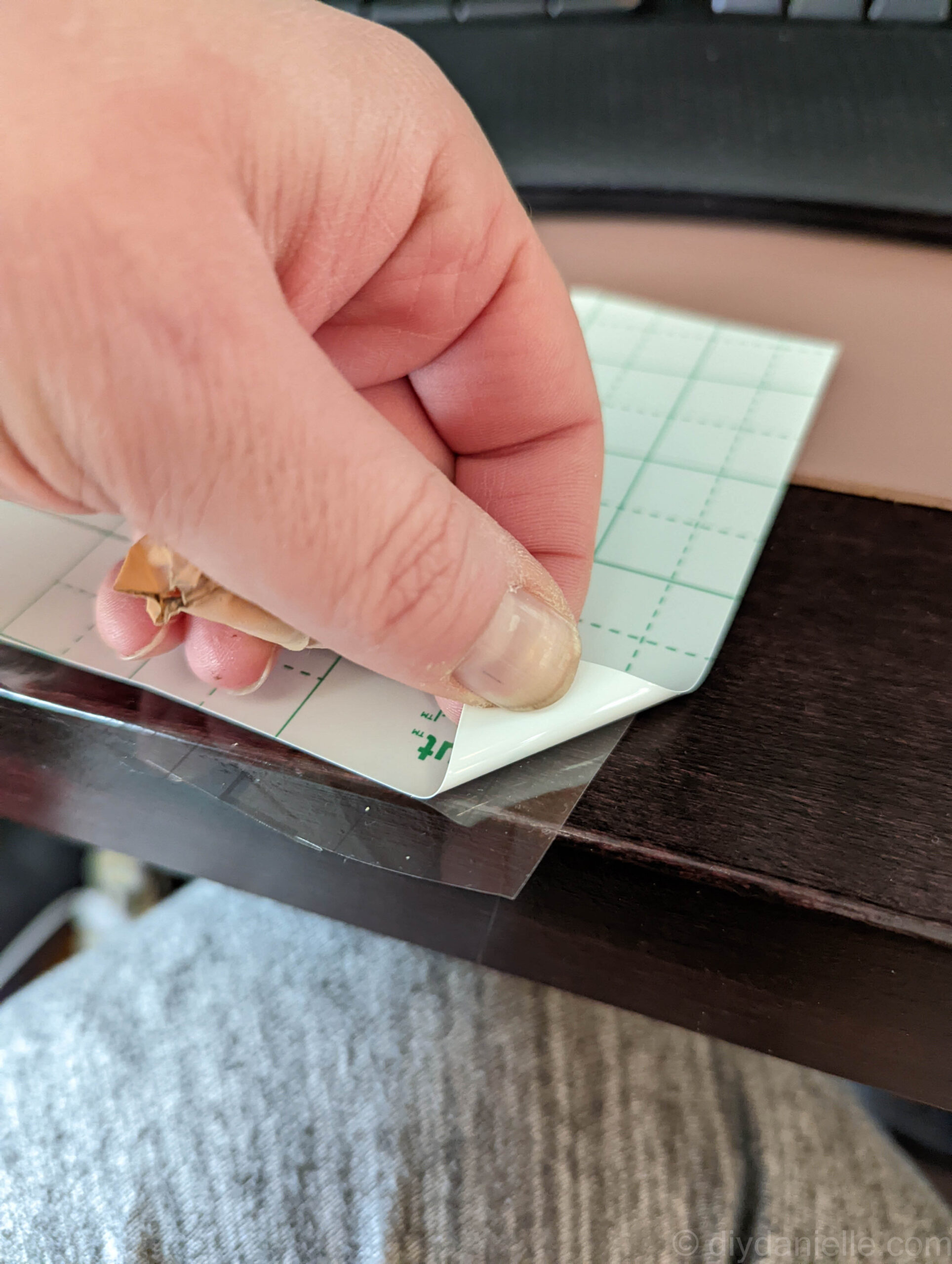 Removing the backing from a piece of permanent vinyl.