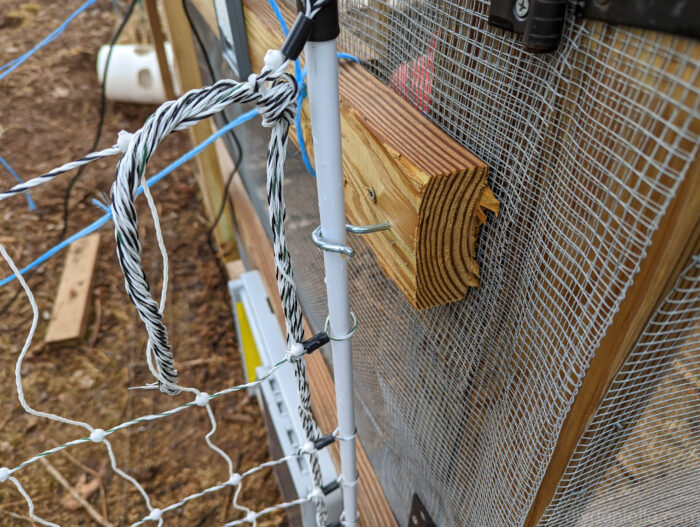 Large screw hook holds the PoultryNet fence close to my chicken coop corner so predators can't get through.