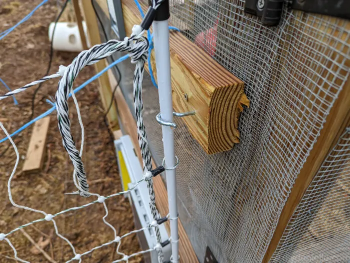 Large screw hook holds the PoultryNet fence close to my chicken coop corner so predators can't get through.