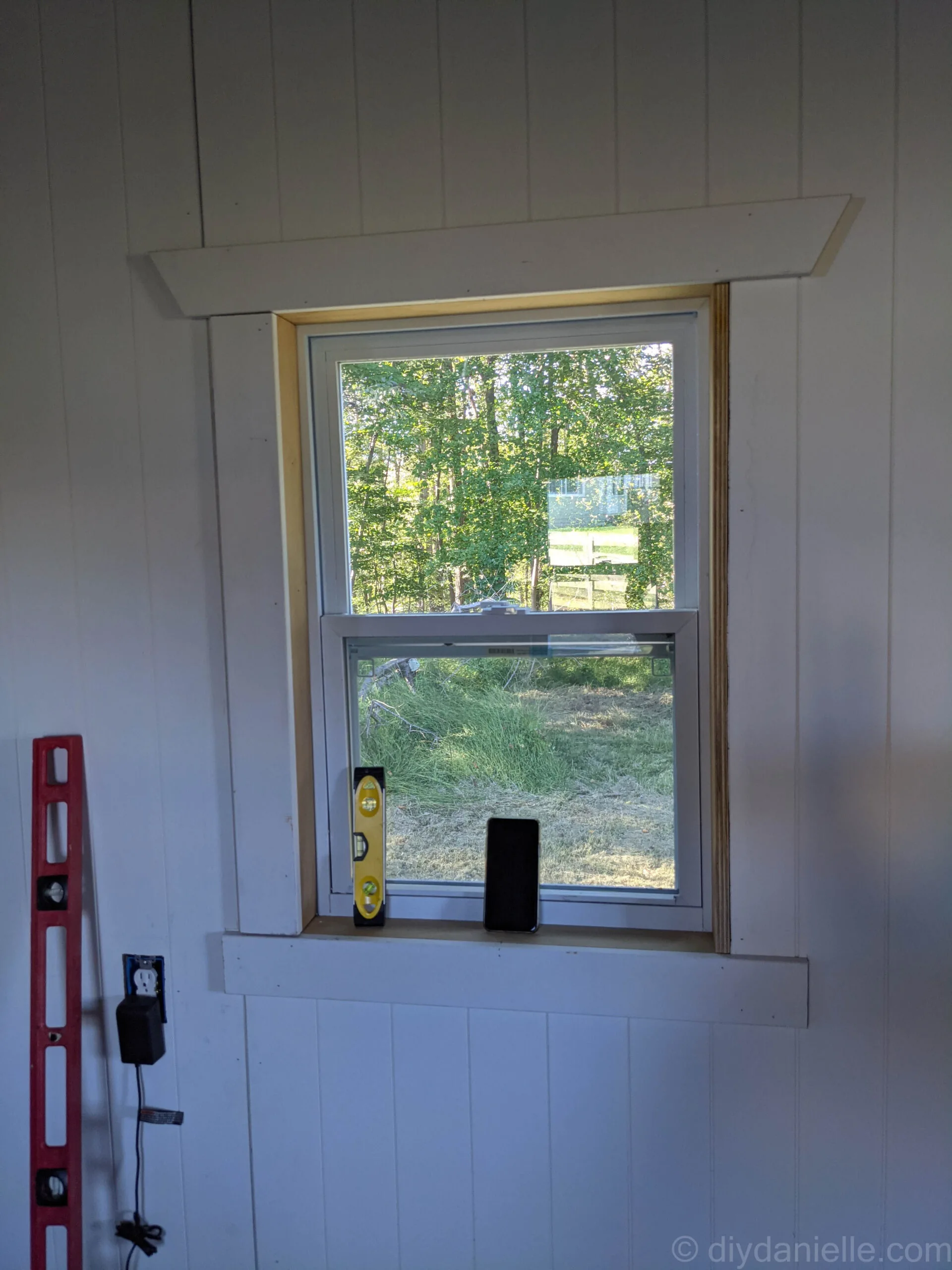 As you can see above, the left side casing has been attached, but the right side casing has not. As a result, you can see the raw edge of the piece of plywood we used to build the window jams.
