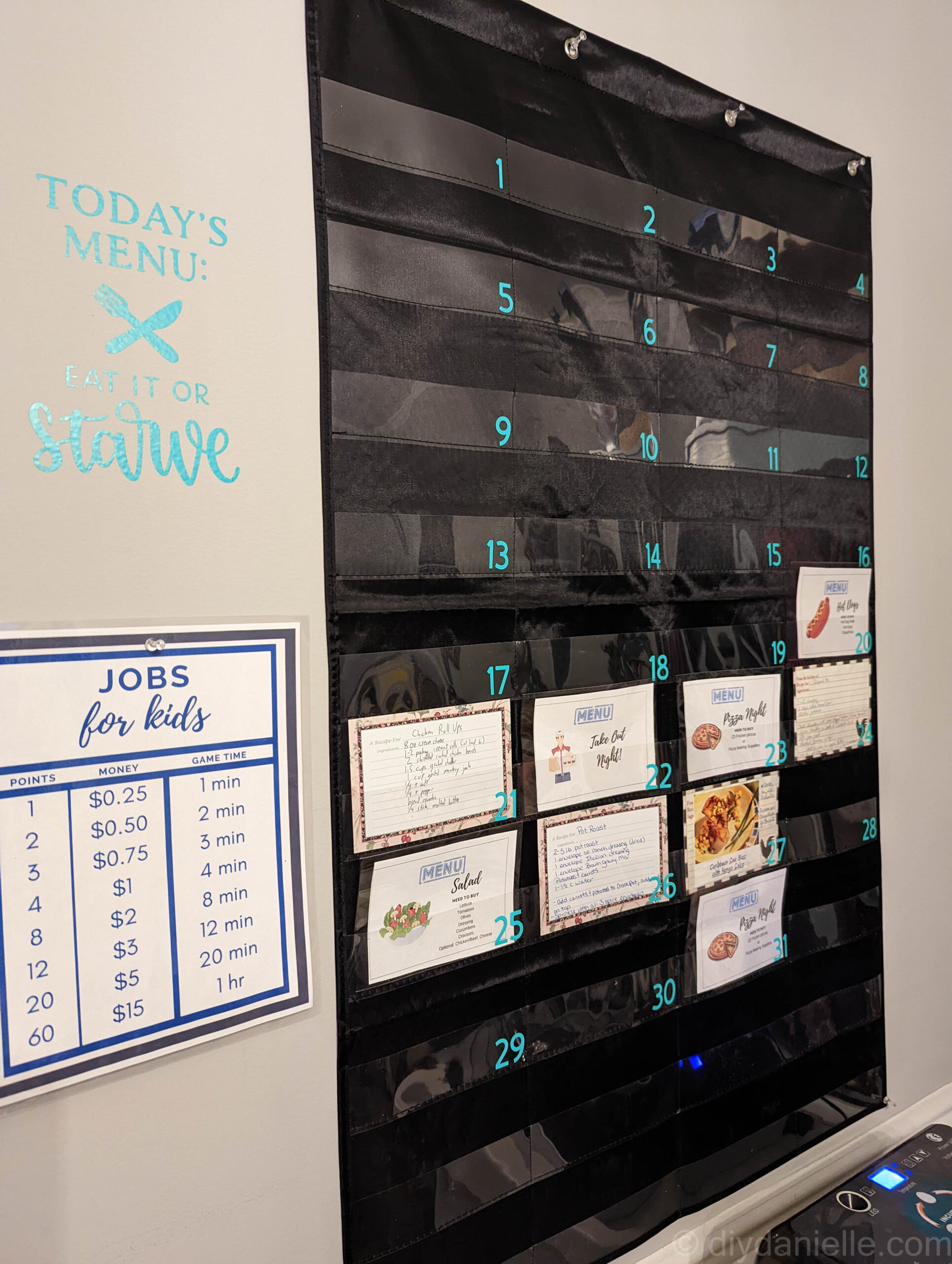 Menu planner setup next to my chore chart. Pockets for days 20-27 and day 31 have recipe cards in them.