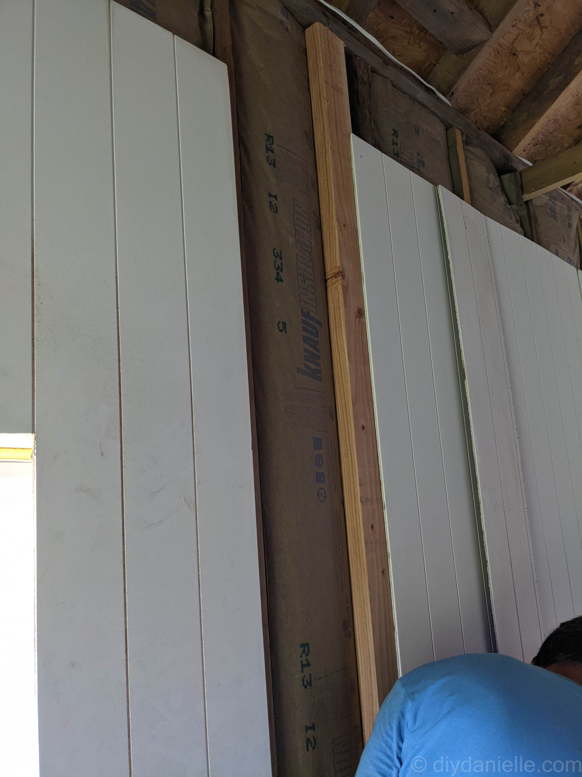 In this photo, we placed an 8' 2x4 into the stud bay where the two panels will meet. The large side of the 2x4 is facing out and the 2x4 is screwed into the top and bottom of the studs supporting the wall. One PDF panel is installed and there's another waiting to be placed.