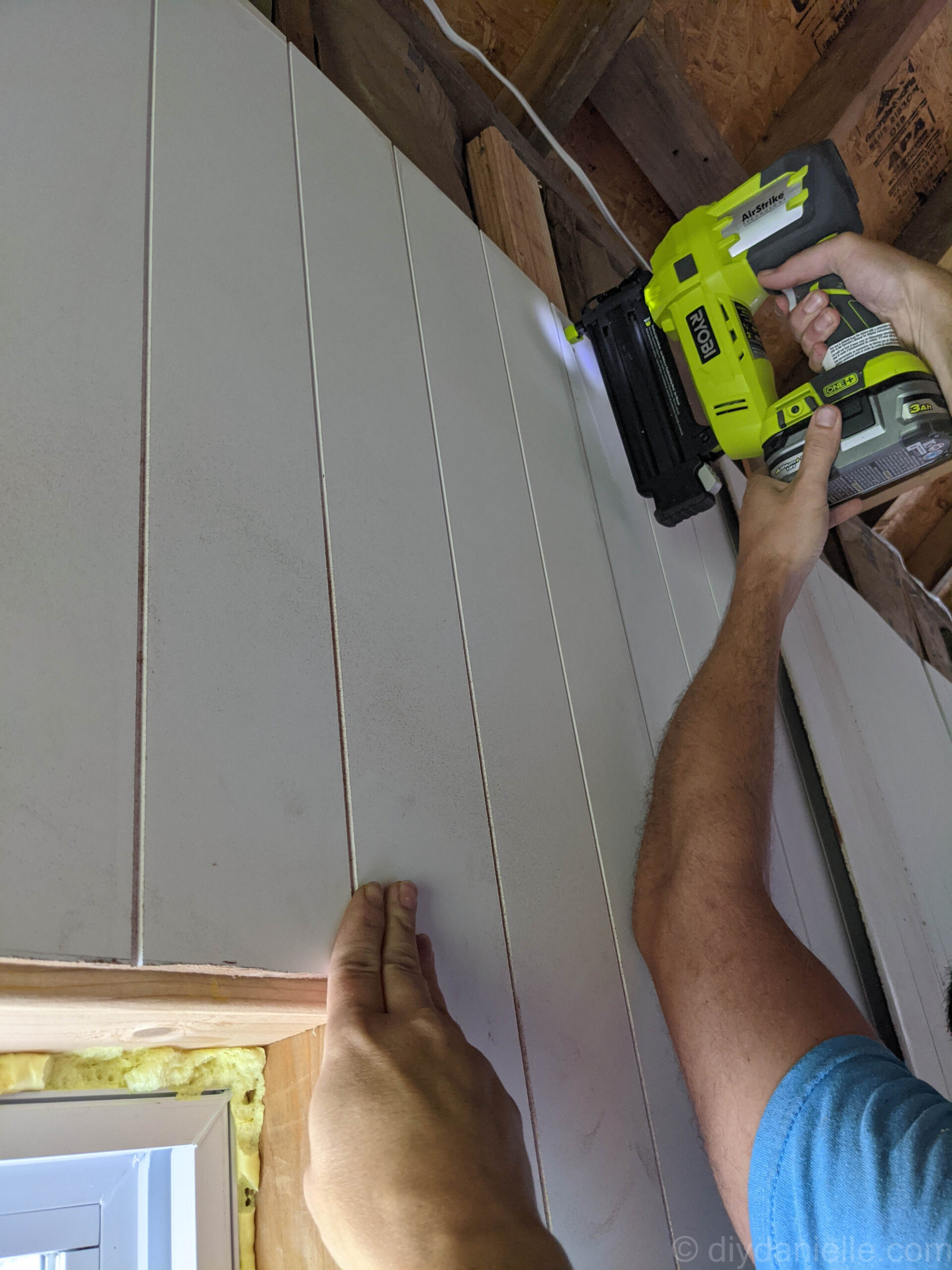 Using a Ryobi Air strike to attach paneling to studs. 