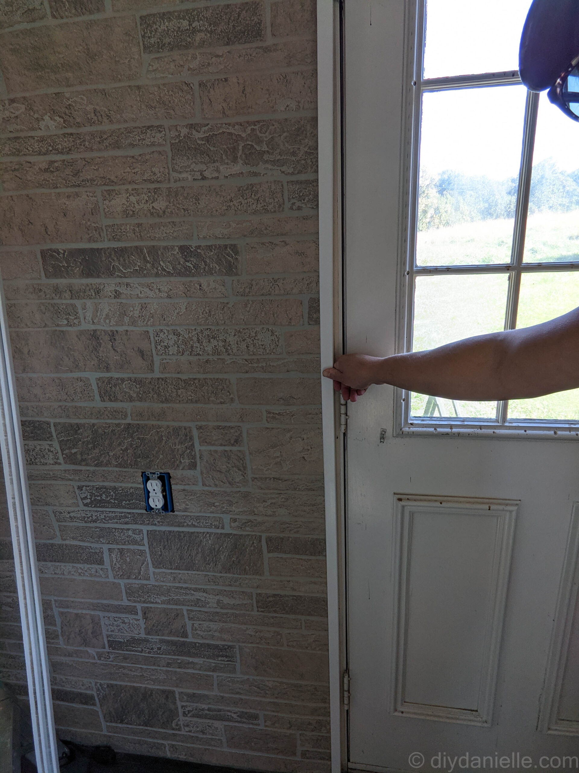 Using PVC corner trim around a door frame to hide the raw edges of the paneling. 