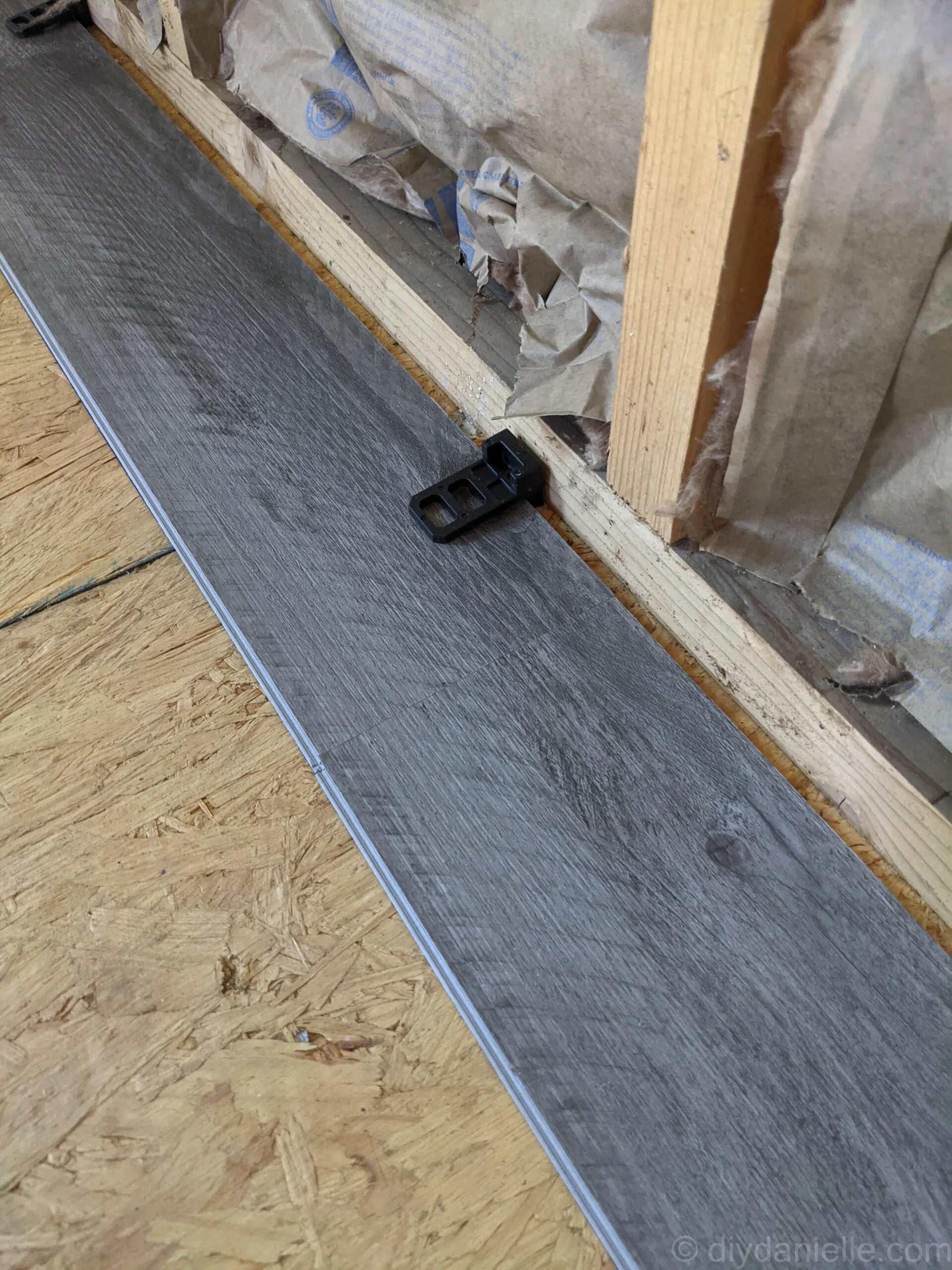 Close-up of vinyl plank flooring tongue and groove edges fitting tightly together during installation.
