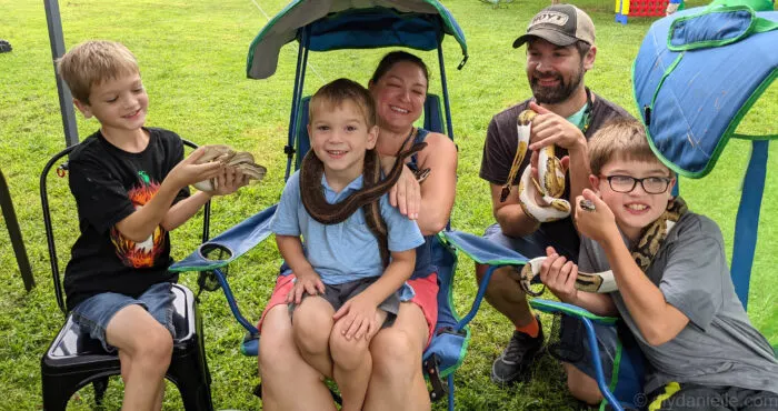 My family all holding snakes for a family photo at the reptile party!